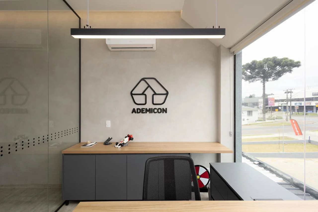 Estação de trabalho individual com bancada em madeira e logo Ademicon
