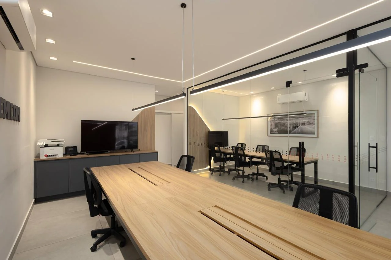 Ambiente integrado com divisórias de vidro e iluminação linear arquitetônica