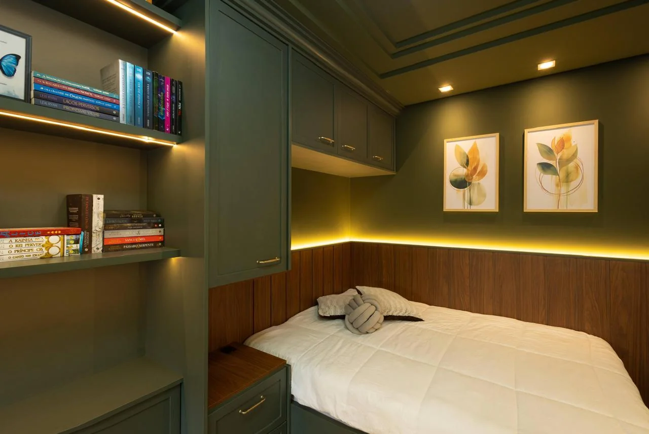 Detalhe da cama com armários superiores planejados e iluminação embutida